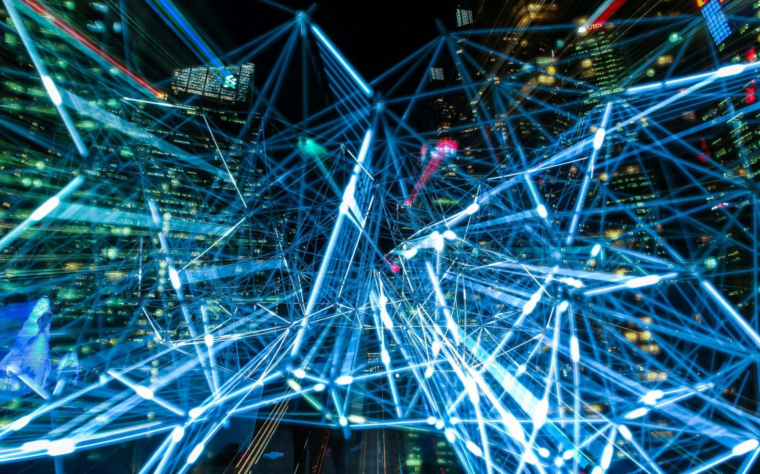 Dynamic urban scene showcasing interconnected light trails representing digital communication networks.